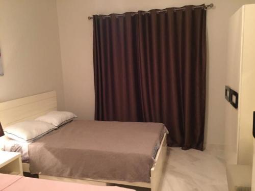 亚历山大Lovely 3-bedroom vacation home -Marassi的一间卧室配有床和棕色窗帘