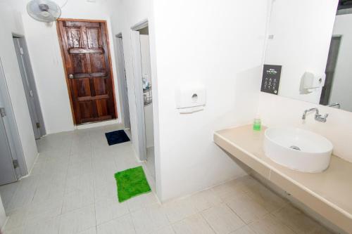 拜县Mad Monkey Pai的白色的浴室设有水槽和绿色地毯。