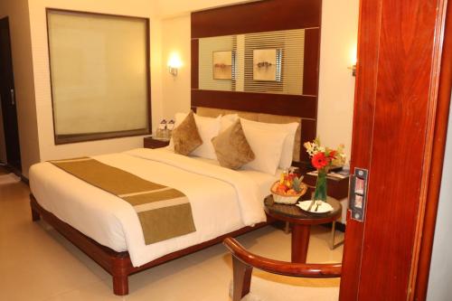 印多尔Kyriad Hotel Indore by OTHPL的一间卧室配有一张大床和一张桌子