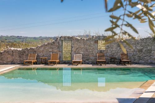 洛特河畔卡斯泰尔莫龙蓝宝旅馆的一个带椅子和石墙的游泳池