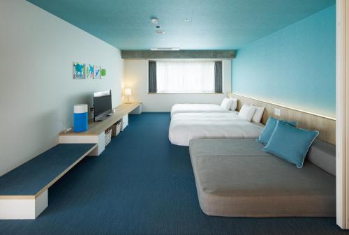 恩纳Hoshino Resorts BEB5 Okinawa Serakaki的酒店客房,设有两张床和一张沙发