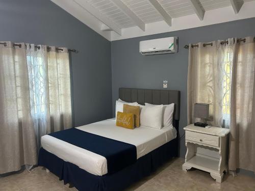 法尔茅斯Williams Oasis的一间卧室配有一张带蓝色墙壁和窗帘的床