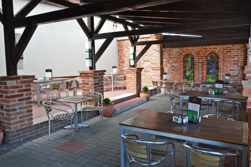 赛特古特哈德Andante Pension & Restaurant的砖砌建筑中带桌椅的庭院