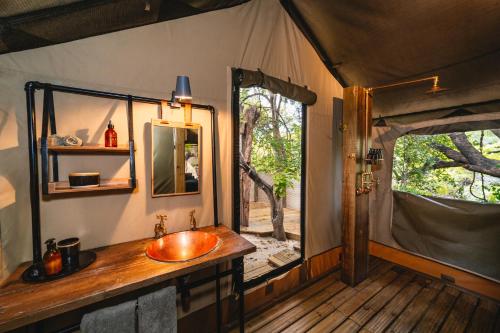 维多利亚瀑布Tsowa Safari Island的帐篷内的浴室设有水槽和镜子