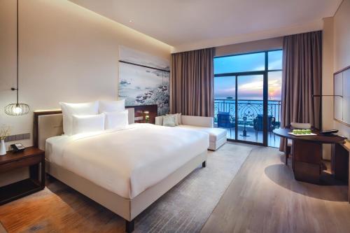 岳阳岳阳铂尔曼酒店的酒店客房设有一张大床和一个阳台。