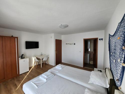 苏佩塔尔Apartmani Neva Supetar的酒店客房配有一张床铺和一张桌子。