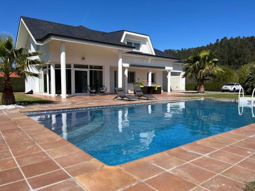 ParbayónVilla LA PERLA con piscina privada的房屋前的游泳池