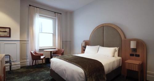 波塔灵顿Portarlington Grand Hotel的酒店客房设有床和窗户。