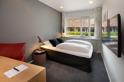 斯坎讷堡斯坎讷堡公园酒店的一间卧室配有一张床、一张书桌和一个窗户。