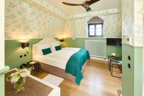 Trechtingshausen伯格莱兴施特因酒店的一间卧室设有一张带绿色墙壁和天花板的床。