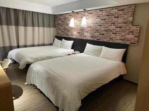 台北苓旅中山馆-Lininn ZhongShan的酒店客房带两张床和砖墙