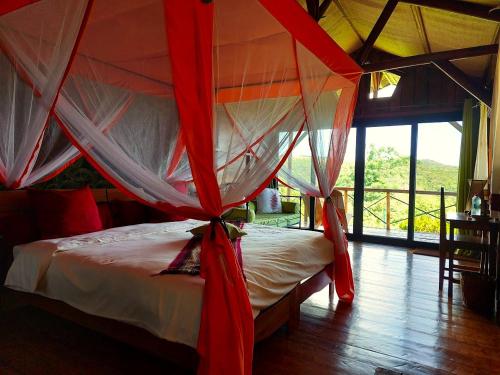 迭戈苏瓦雷斯Nature Lodge的卧室配有红色和白色窗帘的床