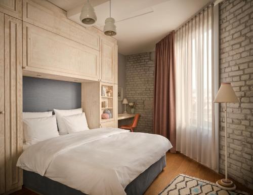 美因河畔法兰克福利波尔提那林登贝格酒店的卧室设有一张白色大床和一扇窗户。