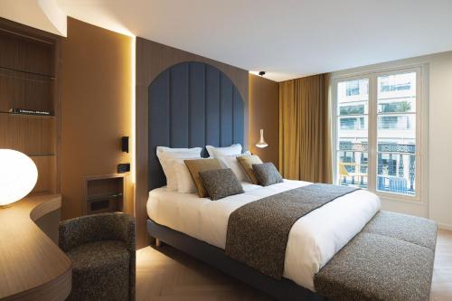 巴黎La Source Exclusive Apartment的配有一张床和一把椅子的酒店客房