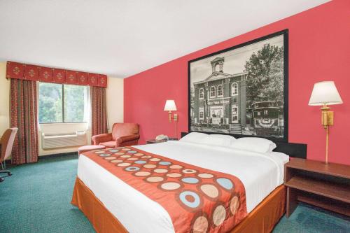 盖茨堡葛底斯堡速8酒店的酒店客房设有一张大床和红色的墙壁。