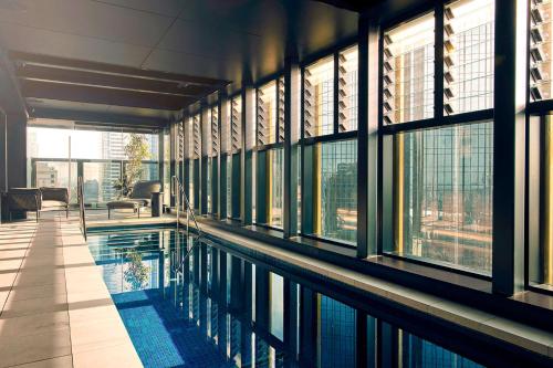 墨尔本Quincy Hotel Melbourne的一座带窗户的建筑中央的游泳池