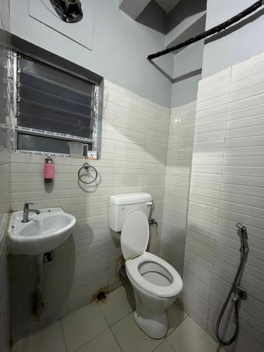 古瓦哈提Urban Inn Rukminigaon的一间带卫生间和水槽的浴室
