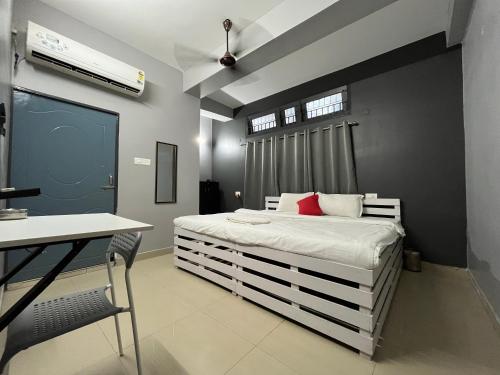 古瓦哈提Urban Inn Rukminigaon的卧室配有白色的床和红色枕头