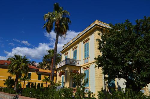 阿拉西奥Alaxia Luxury Apartments的一座黄色房子,前面有一棵棕榈树