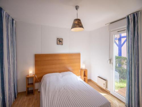 苏斯通Vacancéole - les villas du lac的一间卧室设有一张床和一个大窗户