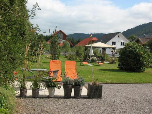 蒂蒂湖-新城Haus Schwedes的院子里两把橙色椅子和植物