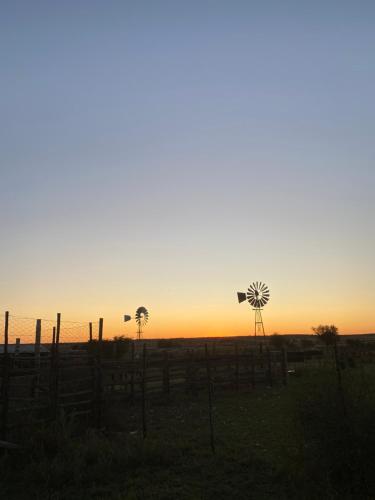 HopetownWiida Gasteplaas的一片落日,在田野上有两个风车
