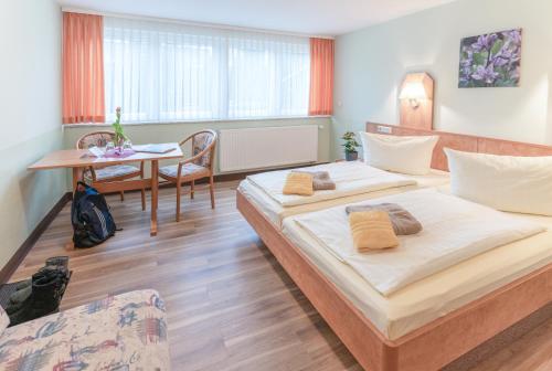 奥伯霍夫Hotel Thüringenschanze的酒店客房设有两张床和一张桌子。