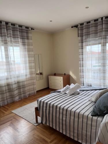 博尔索-德尔格拉帕Appartamenti Ziliotto的一间卧室配有一张带条纹床单的床和窗户。