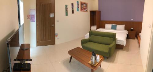 金宁乡熊宝贝民宿的酒店客房带绿椅和一张床