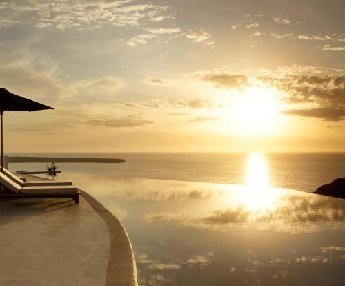 伊亚Santo Pure Oia Suites & Villas的阳光下在海洋上的游泳池