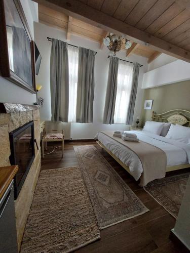 约阿尼纳VIRSA BOUTIQUE ROOMS的一间卧室设有一张大床和一个壁炉