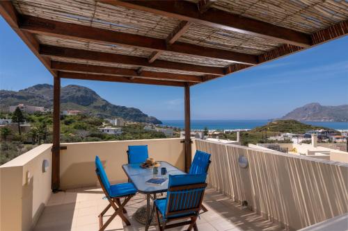 普拉基亚斯Plakias Panorama Homes的海景阳台上的桌椅