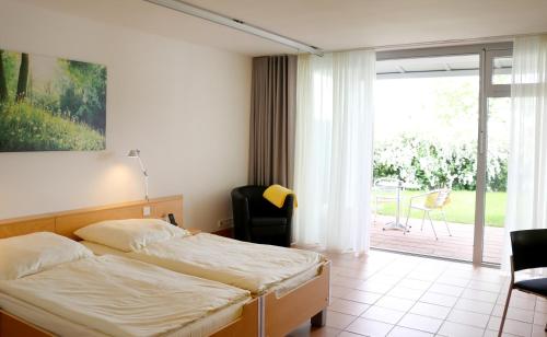 Lobbach曼弗雷德 - 绍尔基金会研讨会酒店的一间卧室设有一张床和一个滑动玻璃门