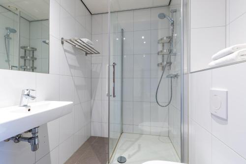 巴德胡弗多普巴德胡弗多普史基浦阿姆拉酒店的一间带玻璃淋浴和水槽的浴室
