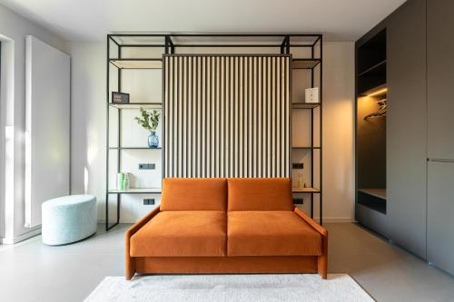 莱比锡YUMA Apartments Leipzig Berliner Straße的衣柜里的一个橙色沙发