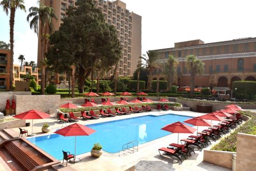 开罗开罗万豪酒店及奥马尔海亚姆赌场的一个带红色遮阳伞和椅子的游泳池