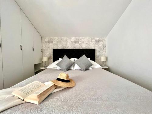 赫瓦尔佩拉公寓的一间卧室配有一张带帽子和书籍的床