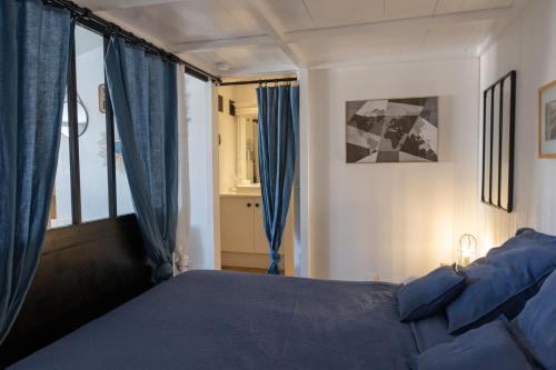圣马丹德雷La Martinoise Studio的一间卧室配有蓝色的床和蓝色窗帘