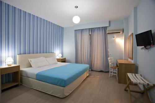 波罗斯Valente Perlia Rooms的一间酒店客房,配有一张床和一台电视