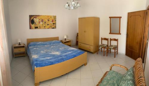 莱乌卡Villa Ciardo的一间卧室配有一张床和一把椅子