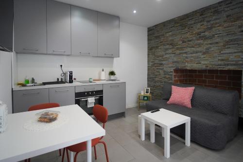 大戈里察Apartments Choice的厨房以及带沙发和桌子的客厅。