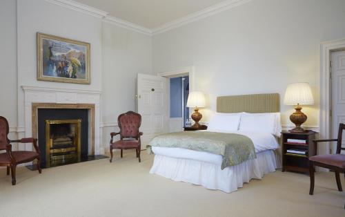 梅努斯梅努斯校园住宿酒店的一间白色卧室,配有一张床和一个壁炉