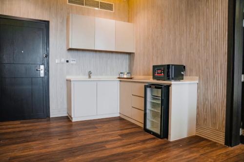 拉斯阿尔卡麦M14 Hotel Apartment的厨房配有白色橱柜和黑色门