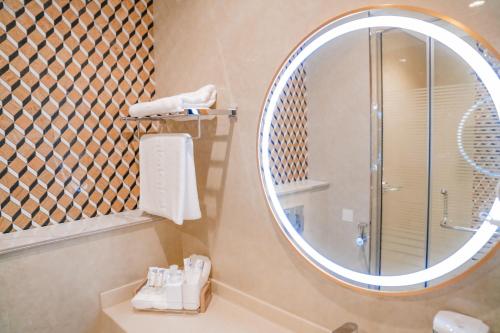 拉斯阿尔卡麦M14 Hotel Apartment的带淋浴和大镜子的浴室