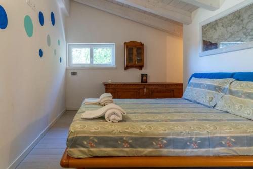 莱维科特尔梅Alle Coccinelle, Levico Terme Ospitar的一间卧室配有一张床,床上有毛巾