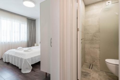 瓦尔纳Cosy apartment in central Varna的一间卧室配有一张床,浴室设有淋浴。