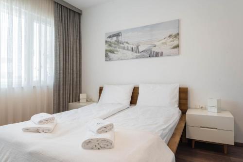 瓦尔纳Cosy apartment in central Varna的卧室设有两张单人床和白色墙壁。