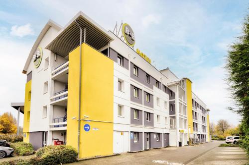 弗雷兴B&B HOTEL Köln-Frechen的公寓大楼拥有黄色和白色