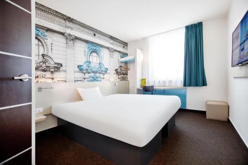 罗兹罗兹市中心B&B酒店的卧室配有白色的床和窗户。