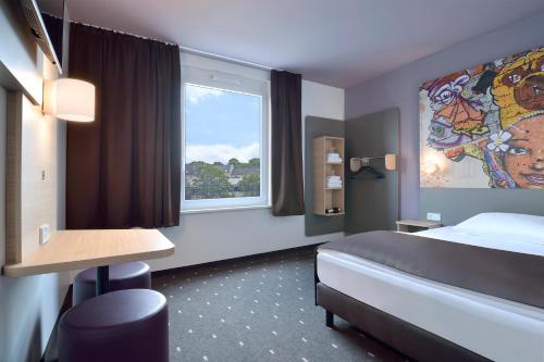 科隆B&B Hotel Köln-Ehrenfeld的酒店客房设有床和窗户。